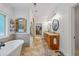 Bright bathroom featuring a soaking tub, double vanity, and an archway mirror with access to the walk-in closet at 1005 Renfroe Lake Dr, Auburn, GA 30011