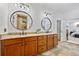 Double vanity bathroom featuring granite countertops and decorative mirrors with a view to the shower at 1005 Renfroe Lake Dr, Auburn, GA 30011