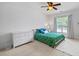 Bright bedroom with a ceiling fan, large window, and floral patterned bedding at 1005 Renfroe Lake Dr, Auburn, GA 30011
