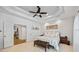 Bedroom with tray ceilings and neutral carpet features a decorative sign above the headboard at 1005 Renfroe Lake Dr, Auburn, GA 30011