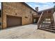 Exterior of a brick home featuring a driveway, two car garage, wooden stairs to deck and a large backyard at 1005 Renfroe Lake Dr, Auburn, GA 30011