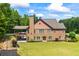 Stately two-story brick home with attached covered patio, manicured lawn and mature trees at 1005 Renfroe Lake Dr, Auburn, GA 30011