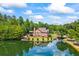 View of the back of the house near the lake surrounded by mature trees at 1005 Renfroe Lake Dr, Auburn, GA 30011