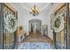 Elegant foyer with decorative doors, tiled floor, and ornate light fixture welcomes you into this stunning home at 1005 Renfroe Lake Dr, Auburn, GA 30011