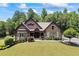 Beautiful brick home with manicured lawn and mature trees, featuring a covered front porch and lush landscaping at 1005 Renfroe Lake Dr, Auburn, GA 30011
