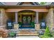 Charming front porch with stone accents, rocking chairs, and decorative wreaths for a welcoming entrance at 1005 Renfroe Lake Dr, Auburn, GA 30011