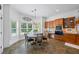 Bright kitchen with wooden cabinets, granite countertops, and adjacent breakfast nook with large windows at 1005 Renfroe Lake Dr, Auburn, GA 30011