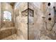 Travertine tiled shower with multiple shower heads, decorative mosaic tile, and built-in bench at 1005 Renfroe Lake Dr, Auburn, GA 30011