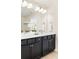 A stylish bathroom featuring a double vanity with white counters and dark cabinets, with a large mirror and sconce lighting at 2813 White Oak Ln, Decatur, GA 30032