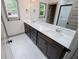 Bathroom with double sinks, dark cabinets, white countertops, and a window view at 5525 Belle Meade Dr, Villa Rica, GA 30180