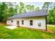 Back exterior with newly installed windows and white siding, and manicured lawn at 5525 Belle Meade Dr, Villa Rica, GA 30180