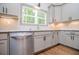 Stylish kitchen featuring a stainless steel dishwasher, and white cabinets at 5525 Belle Meade Dr, Villa Rica, GA 30180