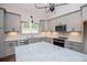 Elegant kitchen showcasing gray cabinets, granite countertops, stainless appliances, and a modern design at 5525 Belle Meade Dr, Villa Rica, GA 30180