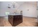 Open concept kitchen featuring a dark wood island, granite counters, modern lighting and open floorplan at 5525 Belle Meade Dr, Villa Rica, GA 30180