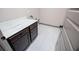 Laundry room features white tile flooring and dark cabinets with marble countertops at 5525 Belle Meade Dr, Villa Rica, GA 30180