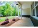 Comfortable front porch with view of mature trees and landscaping. Bricked foundation with white columns at 5525 Belle Meade Dr, Villa Rica, GA 30180