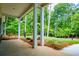 Spacious front porch featuring white columns and beautiful landscaping surrounded by lush trees at 5525 Belle Meade Dr, Villa Rica, GA 30180