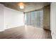Empty bedroom with hardwood floors, large windows, and concrete ceilings at 855 Peachtree Ne St # 2205, Atlanta, GA 30308