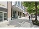 Modern building entrance with large glass windows, planters, and sidewalk with pedestrian at 855 Peachtree Ne St # 2205, Atlanta, GA 30308