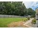 Large backyard with a wooden fence, stone walkway, lush grass, and outdoor dining area at 2711 Bluffton Rd, Buford, GA 30519