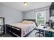 Bedroom with a full size bed, gray walls, a large window and a desk for work or hobbies at 2711 Bluffton Rd, Buford, GA 30519