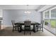 Well-lit dining room featuring a modern chandelier and views of the exterior through a large window at 2711 Bluffton Rd, Buford, GA 30519
