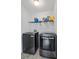 Modern laundry room with front-loading washer and dryer, storage shelves, and tile flooring at 2711 Bluffton Rd, Buford, GA 30519