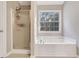 Bright bathroom with a walk in shower, large tub and large window at 3337 Camens Way, Buford, GA 30519