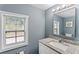 Bathroom with a white vanity, granite countertop, and a patterned window for natural light at 4339 Rushmore Pl, Forest Park, GA 30297