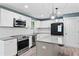 Modern kitchen with stainless appliances, granite countertops, white cabinets, and wood flooring at 4339 Rushmore Pl, Forest Park, GA 30297