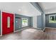 Bright, open-concept living room featuring gray walls, wood flooring, and a red front door at 4339 Rushmore Pl, Forest Park, GA 30297