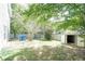 Landscaped backyard featuring storage shed, mature trees, and a wood fence at 4845 Weathervane Dr, Alpharetta, GA 30022