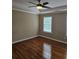 Bedroom with hardwood floors, tray ceiling, and natural light from window at 4845 Weathervane Dr, Alpharetta, GA 30022