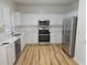 Bright kitchen with white cabinets, stainless steel appliances, and wood flooring at 4845 Weathervane Dr, Alpharetta, GA 30022