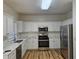 Bright kitchen featuring white cabinets, stainless steel appliances, and light wood-look floors at 4845 Weathervane Dr, Alpharetta, GA 30022