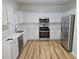 Bright kitchen with white cabinets, stainless steel appliances, and wood flooring at 4845 Weathervane Dr, Alpharetta, GA 30022