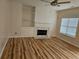 Bright living room featuring wood floors, fireplace, and built-in shelving at 4845 Weathervane Dr, Alpharetta, GA 30022