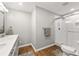 Bright and modern bathroom featuring hardwood floors, a glass shower, and contemporary white vanity at 1444 Arden Sw Dr, Marietta, GA 30008