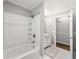 Bright bathroom featuring a shower-tub combo with storage shelves and modern white fixtures at 1444 Arden Sw Dr, Marietta, GA 30008