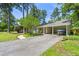 View of driveway leading to a covered carport with a boat, framed by mature trees and landscaping at 1444 Arden Sw Dr, Marietta, GA 30008