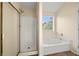 Bright bathroom with a shower and tub featuring a large window at 5718 Hidden Brook Cir, Atlanta, GA 30349
