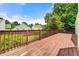 Large outdoor wooden deck with a wood railing surrounded by green vegetation and trees at 5718 Hidden Brook Cir, Atlanta, GA 30349
