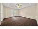 This main bedroom features a tray ceiling, ceiling fan and patio access at 5718 Hidden Brook Cir, Atlanta, GA 30349