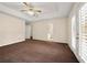 Main bedroom boasts a tray ceiling, ceiling fan, and a door to a patio at 5718 Hidden Brook Cir, Atlanta, GA 30349