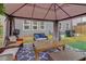 Backyard patio with modern outdoor seating, fan, gray canopy, a grill, and an inviting ambiance at 7246 Gladstone Cir, Lithonia, GA 30038