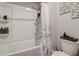 Bathroom with a tub-shower, tiled walls, and toiletries on built-in shelves at 7246 Gladstone Cir, Lithonia, GA 30038