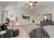 Large bedroom with neutral carpet, ceiling fan, a leather couch, and open doorways at 7246 Gladstone Cir, Lithonia, GA 30038