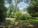 View of a home with a rustic roof and lush green front yard, framed by an old tree at 1526 Snapfinger Rd, Decatur, GA 30032