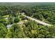 Wide aerial perspective of a neighborhood with lush trees, showcasing a home near a river and a main road at 1535 Pathfinder Sw Way, Lilburn, GA 30047