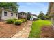 Landscaped backyard with a stone path leading to an upper deck and additional buildings at 1535 Pathfinder Sw Way, Lilburn, GA 30047